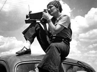 Dorothea Lange on top of car photographing migrants